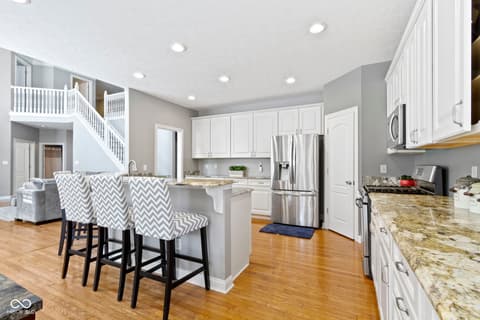 Kitchen at 14825 Latitude Way, Fishers, IN — Bright modern kitchen with island and stainless appliances.