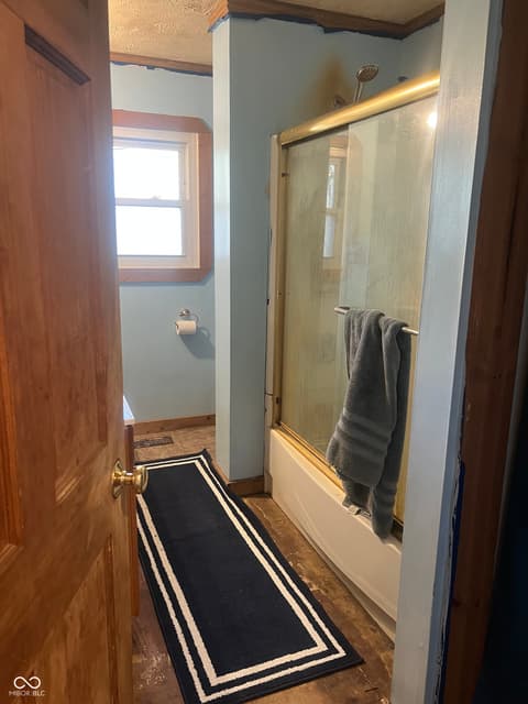 Primary bathroom at 6160 E 116th Street, Fishers, IN — Bright bathroom with classic shower and hardwood floors.