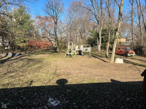Yard at 6160 E 116th Street, Fishers, IN — Large wooded lot with established trees and fencing.