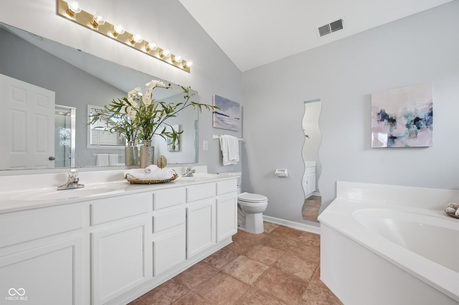 Spa-like primary bath with double vanity and soaking tub.