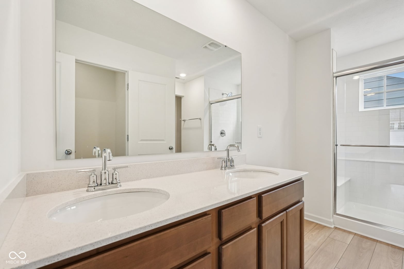 Spacious primary bath with dual vanity and modern finishes.