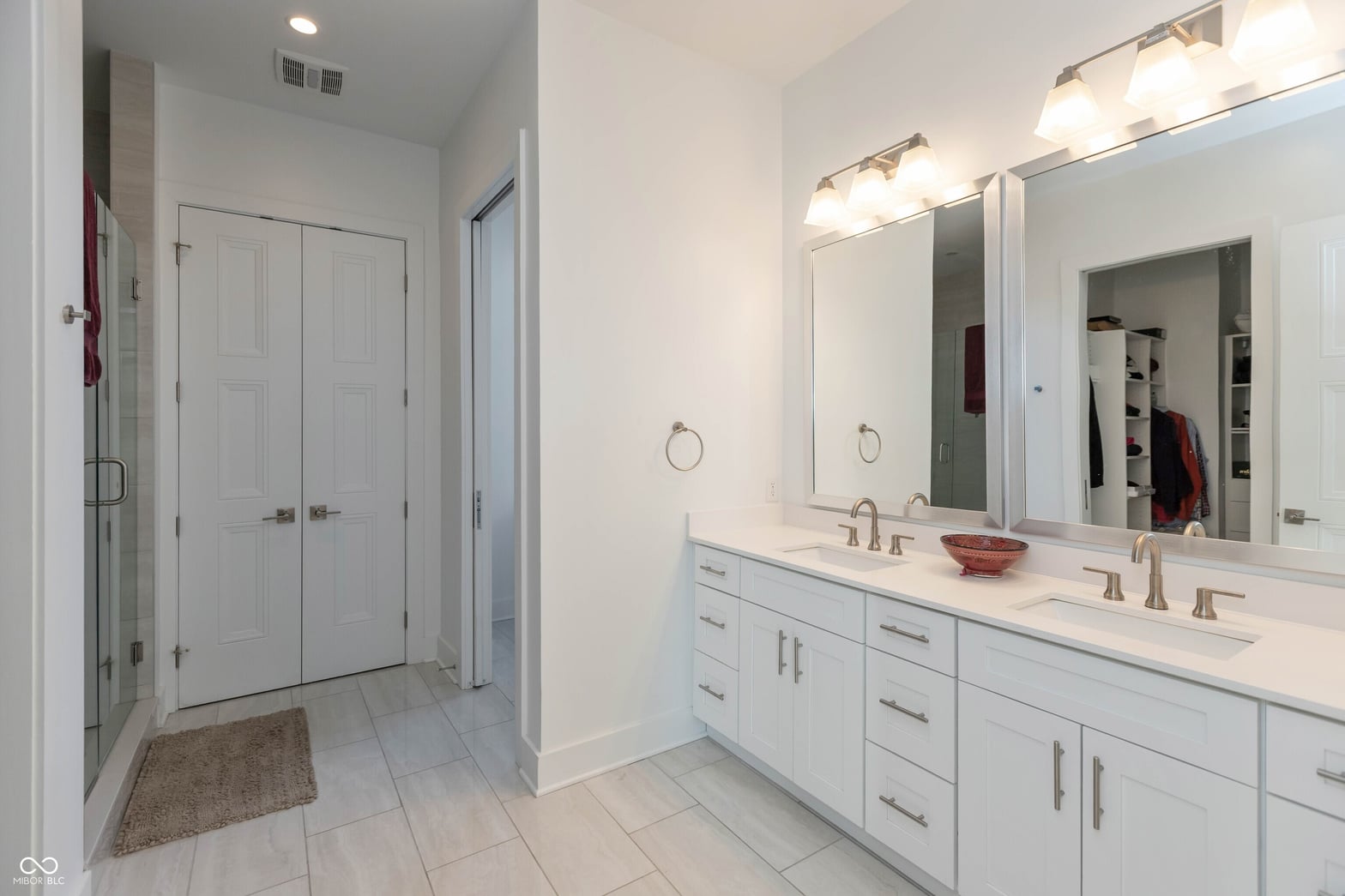 Luxurious primary bath with double vanity and walk-in shower.