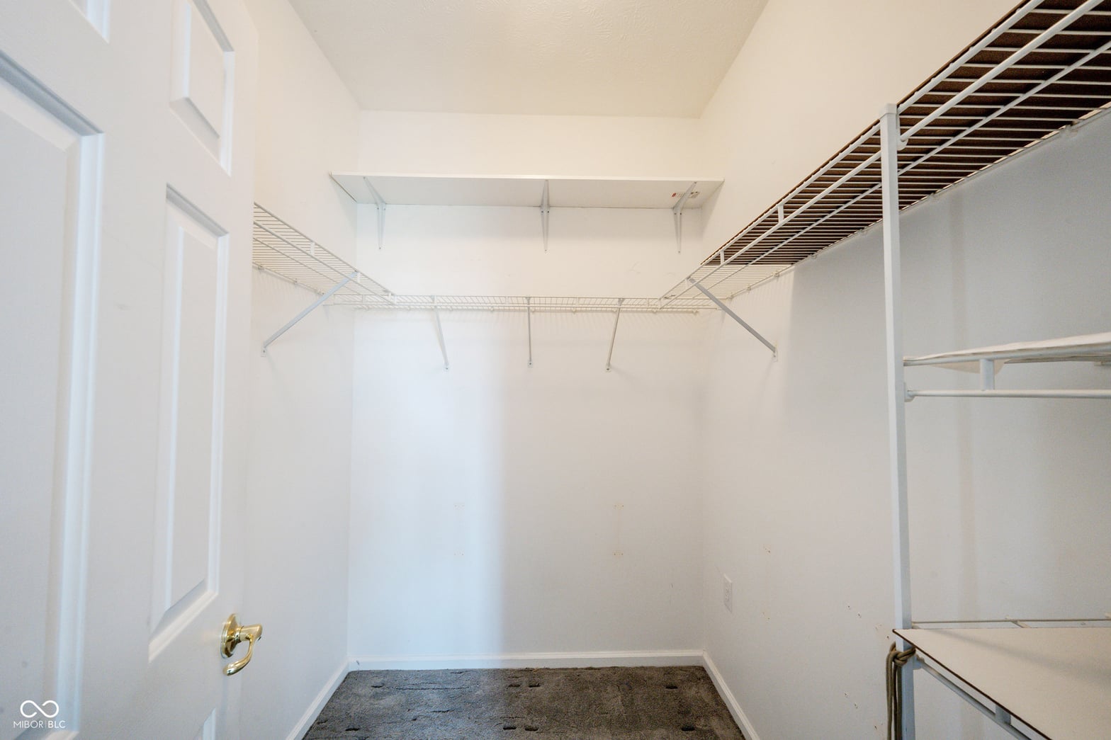 Spacious walk-in closet with multiple storage solutions.
