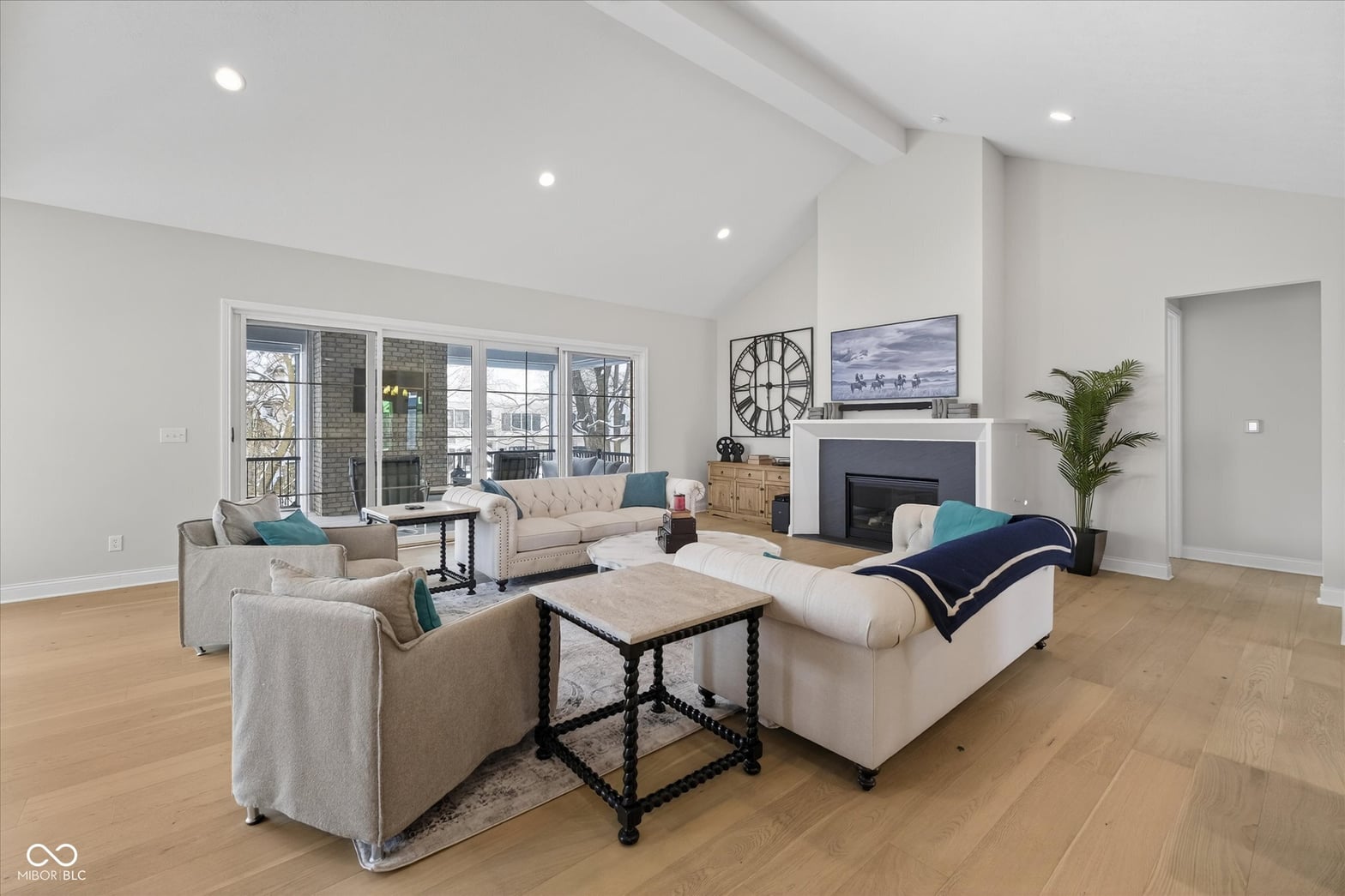 Bright modern living room with fireplace and balcony views.
