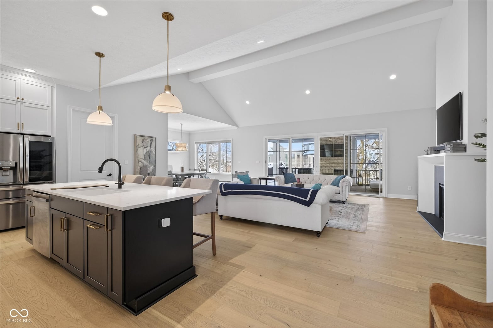 Bright open-concept kitchen and family room with vaulted ceilings.