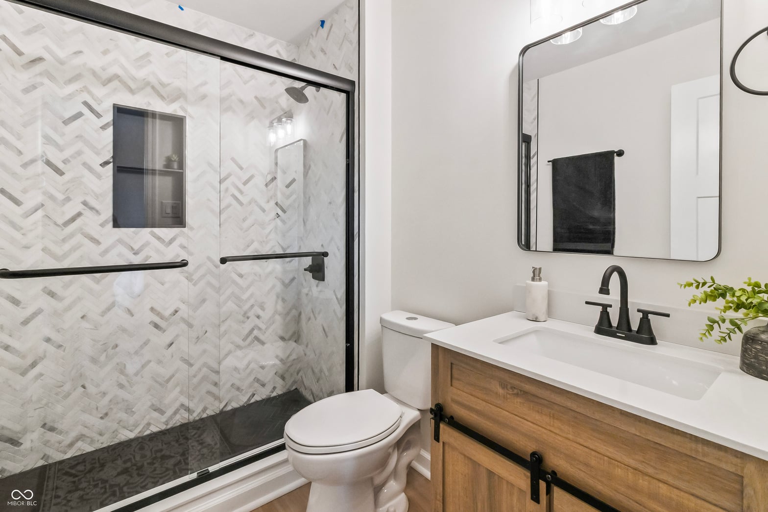 Luxurious primary bath with herringbone marble shower.