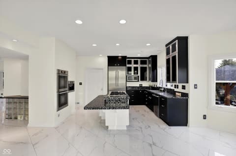 Kitchen at 434 Sheffield Court, Carmel, IN — Modern kitchen with marble floors and black cabinetry.