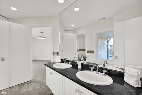 Primary bathroom at 434 Sheffield Court, Carmel, IN — Spacious primary bath with dual vanity and granite counters.