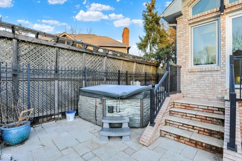 Outdoor living area at 434 Sheffield Court, Carmel, IN — Spacious patio with hot tub and privacy fencing.