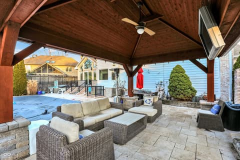 Outdoor living area at 434 Sheffield Court, Carmel, IN — Luxurious covered outdoor living with pool and fireplace.