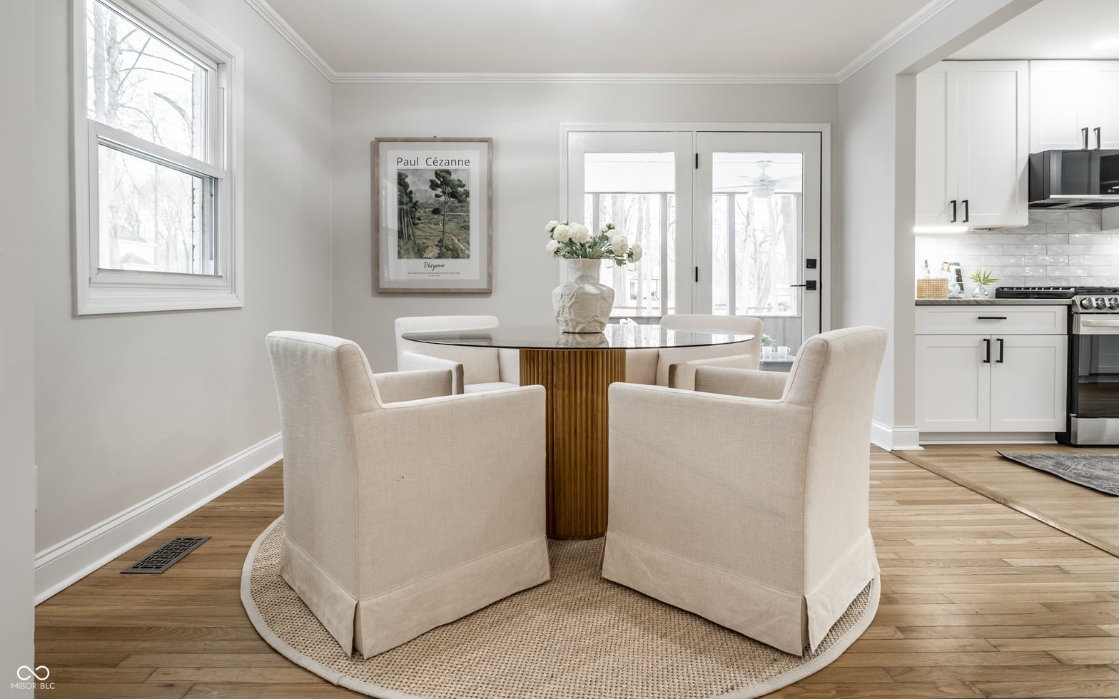 Modern dining area with round glass table and natural light.