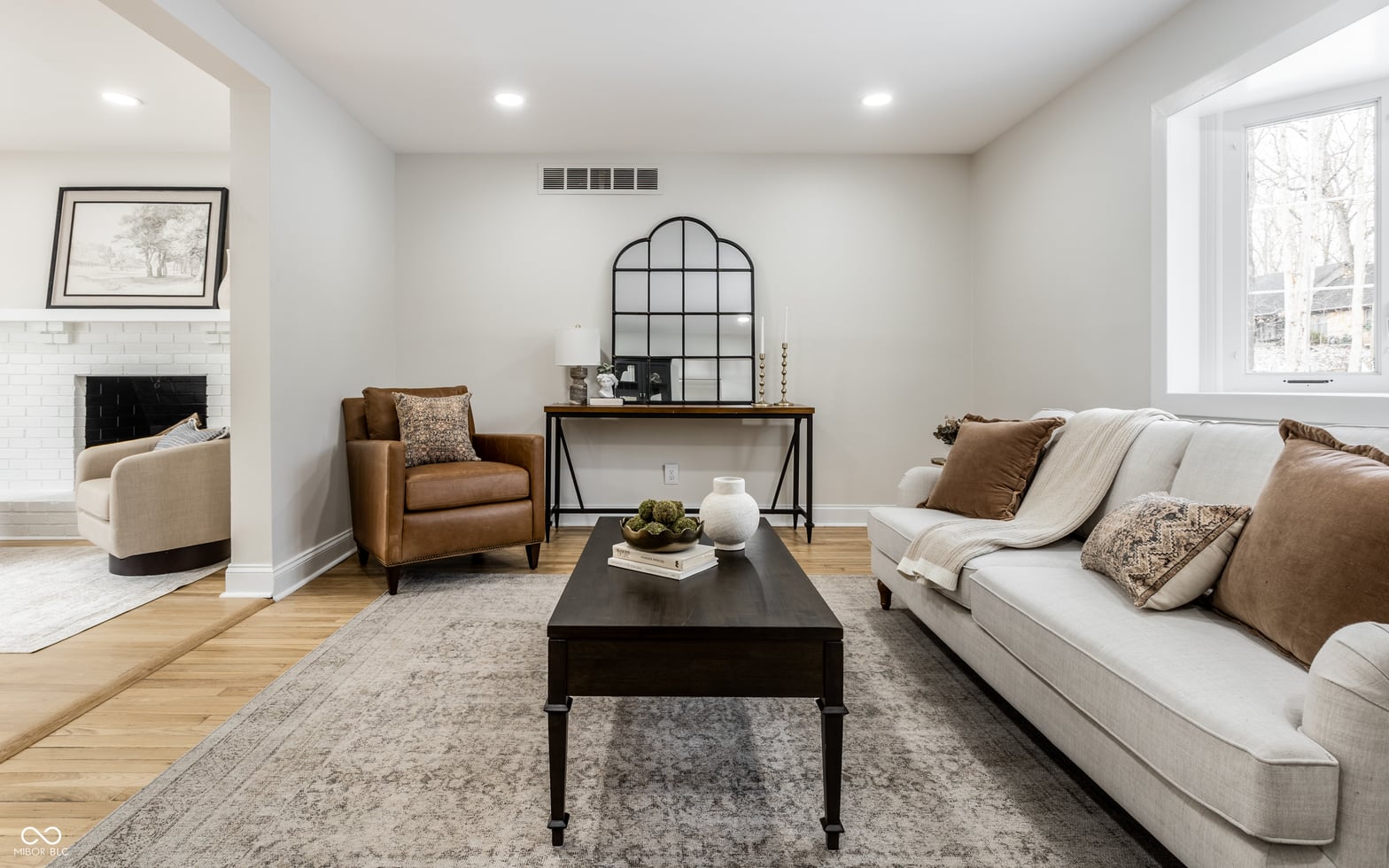 Bright, airy living room with fireplace and hardwood floors.