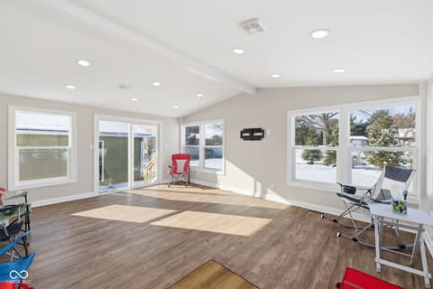 Family room at 15545 Hazel Dell Road, Noblesville, IN — Bright lakeside family room with expansive glass doors.