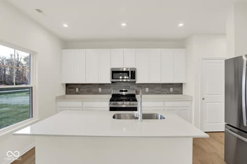 Kitchen at 1353 Mahoning Road, Sheridan, IN — Modern kitchen with white cabinets and quartz island.