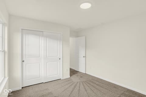 Primary bedroom at 1353 Mahoning Road, Sheridan, IN — Bright, spacious bedroom with large closet doors.
