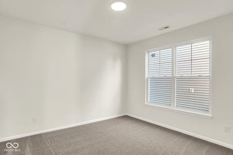 Bedroom at 19773 Highclere Lane, Sheridan, IN — Bright bedroom with plantation shutters and modern fixtures.