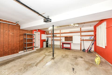 Garage at 13035 Wembly Road, Carmel, IN — Spacious garage with storage shelving and workbench.