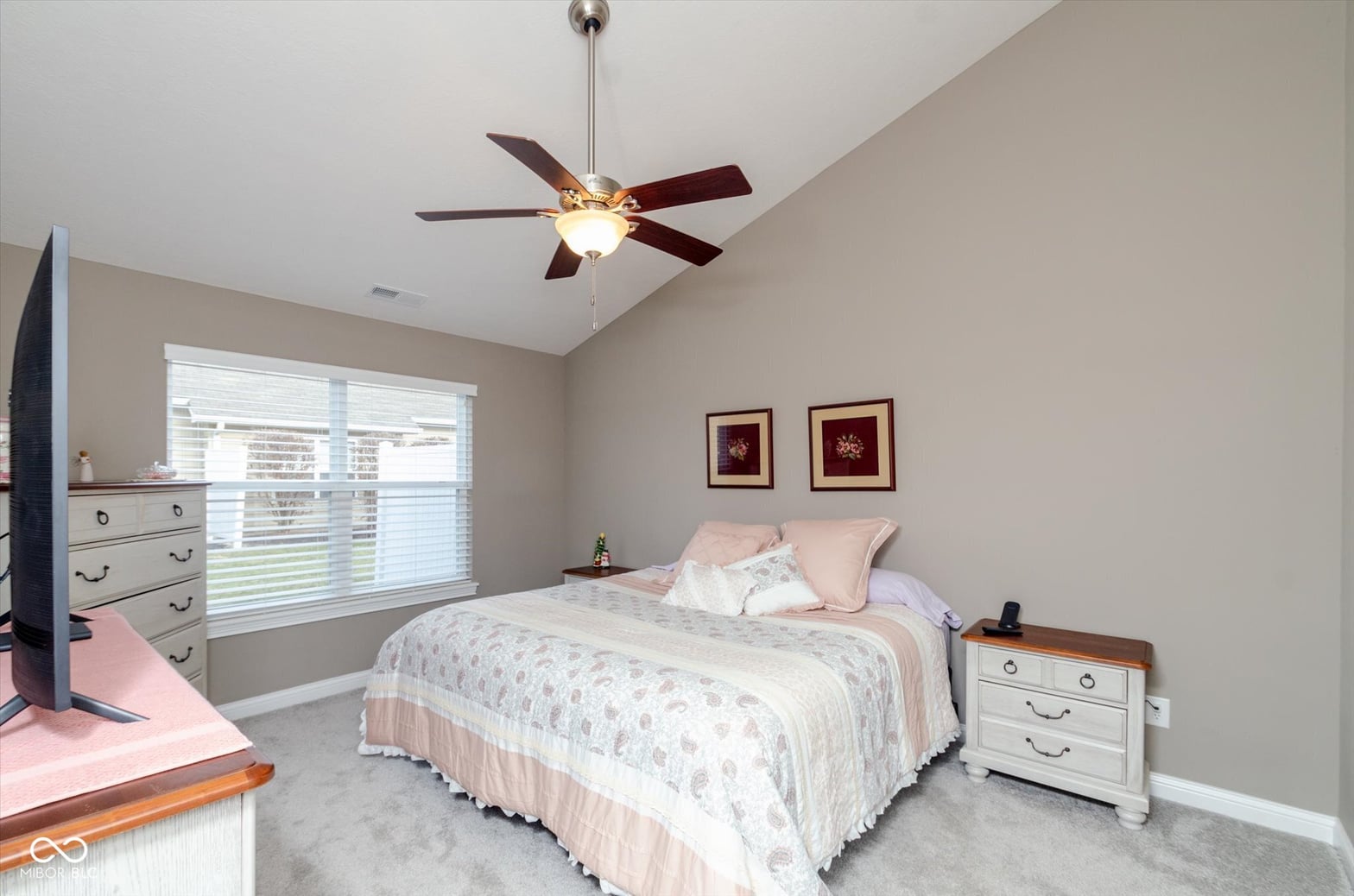 Bright bedroom with vaulted ceiling and glass door access.