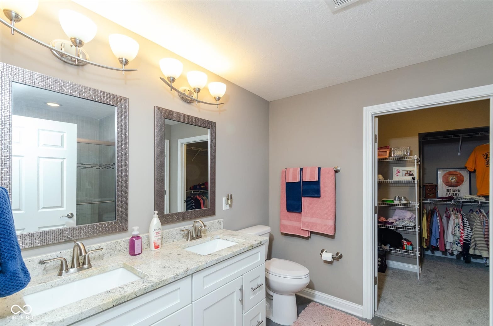 Spacious primary bath with dual vanity and walk-in closet.