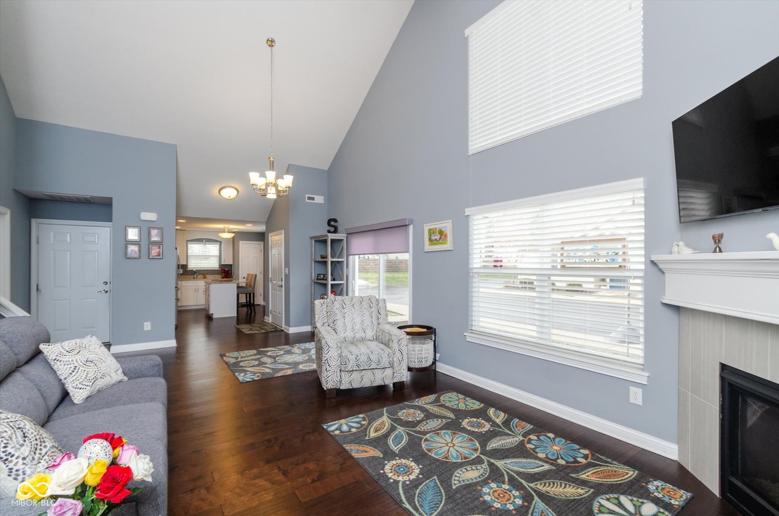 Bright living room with fireplace and vaulted ceilings.