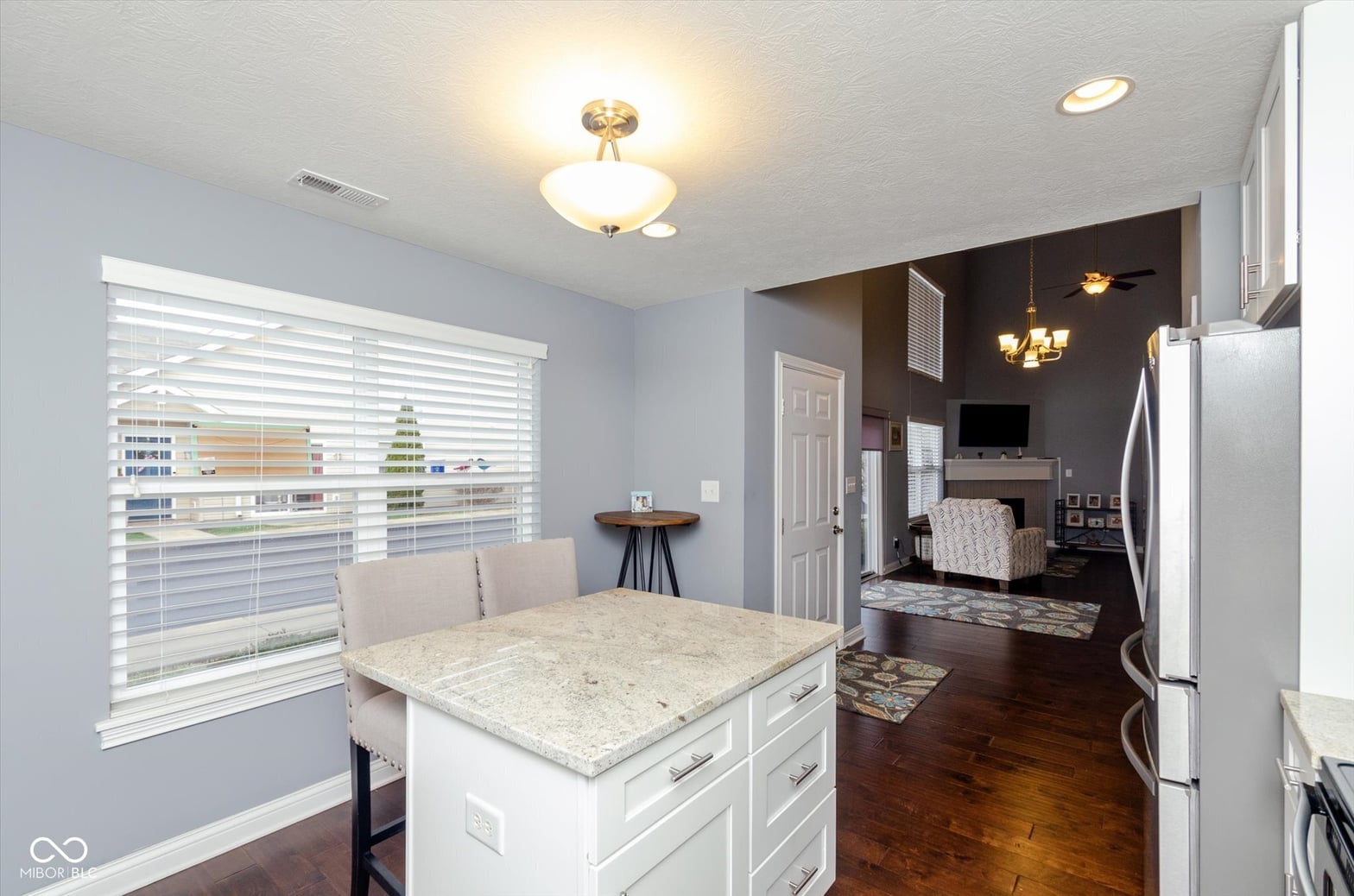 Open kitchen with granite island overlooking living space.