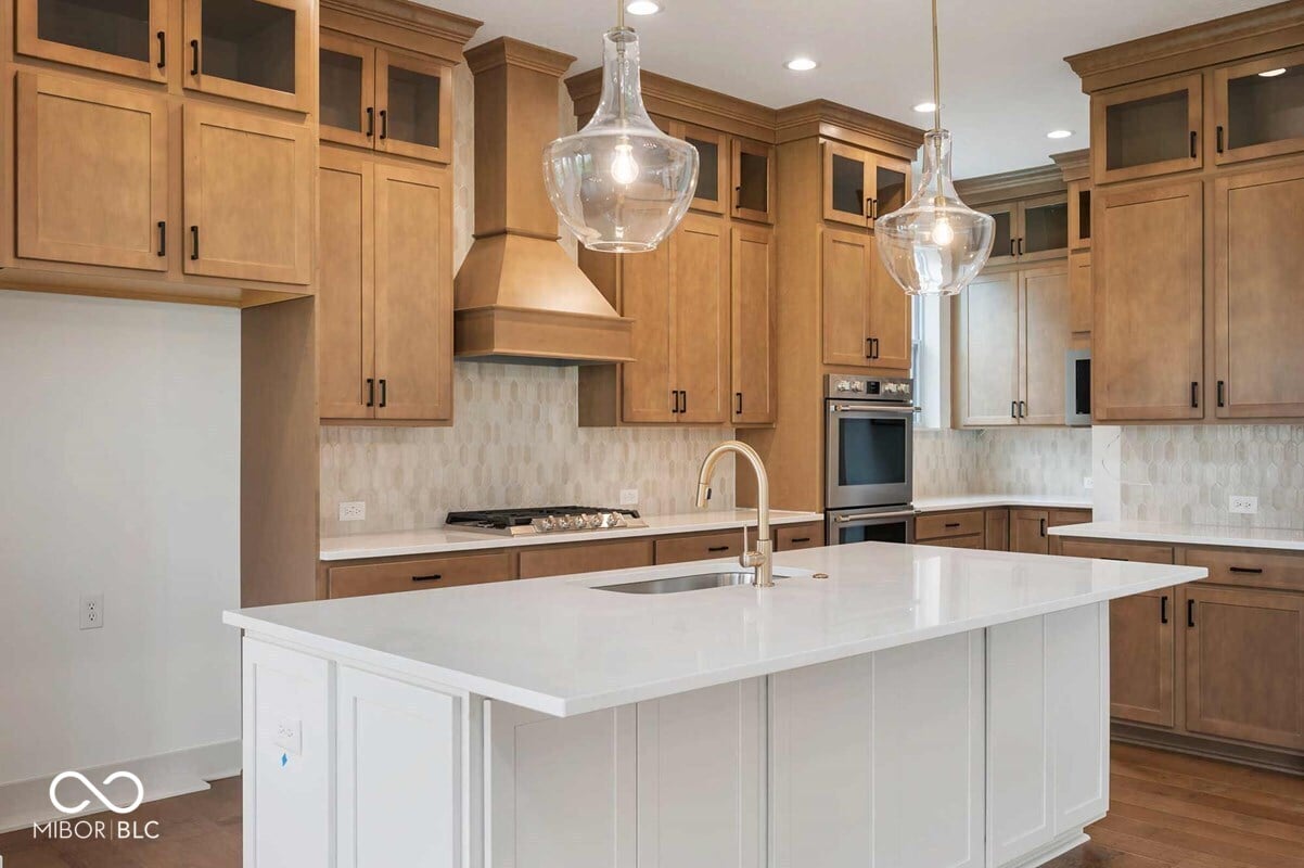 Spacious kitchen with white island and wood cabinetry.