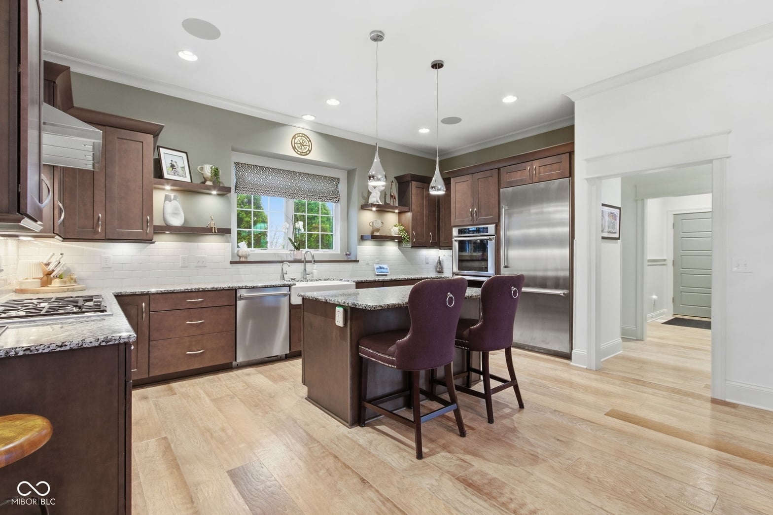 Luxurious kitchen with granite, stainless steel, and island seating.