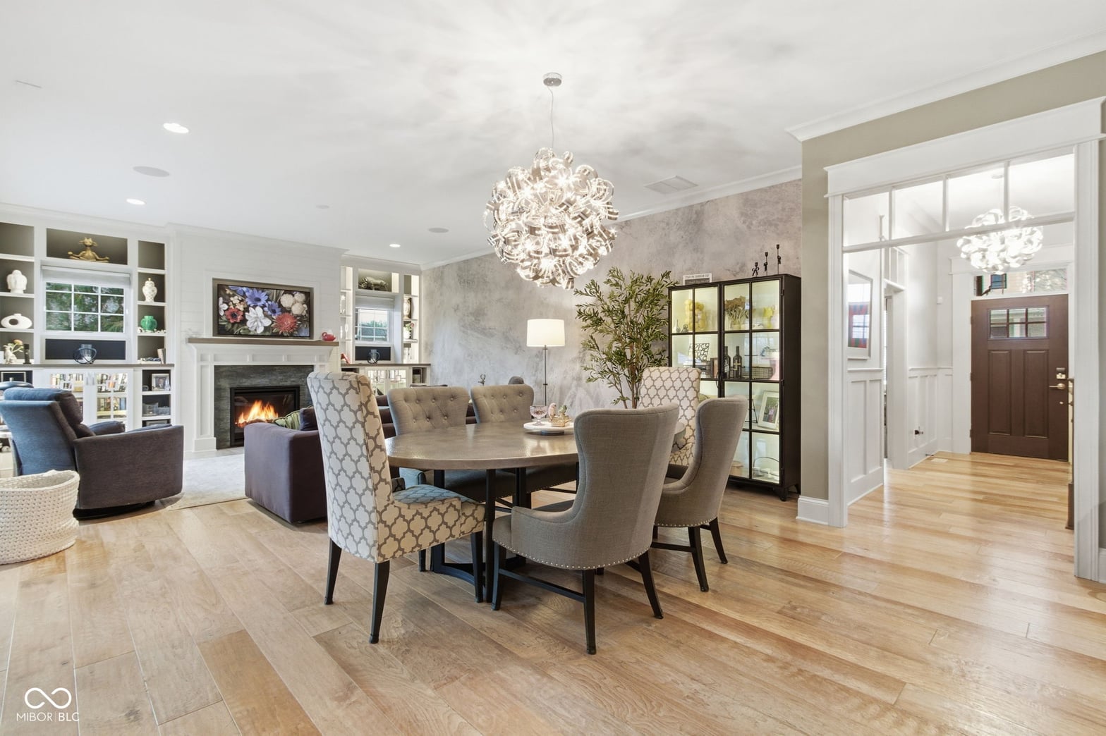 Open-concept dining with fireplace and built-in shelving.