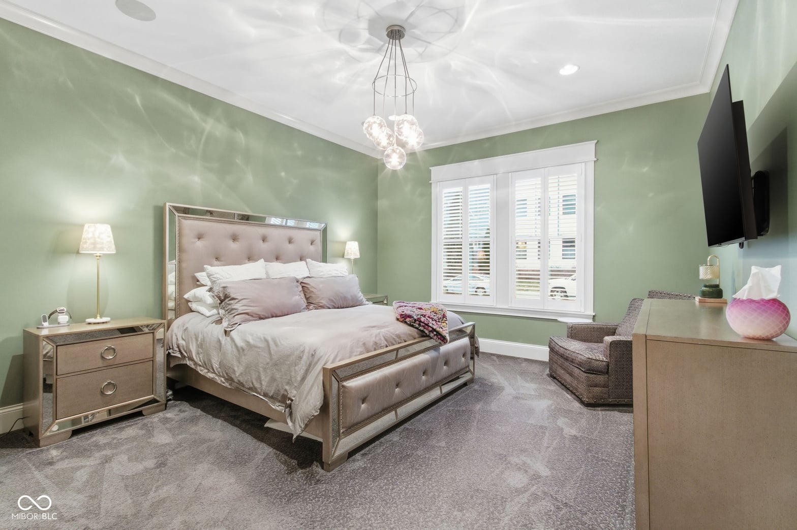 Elegant primary suite with soft sage walls and designer furnishings.