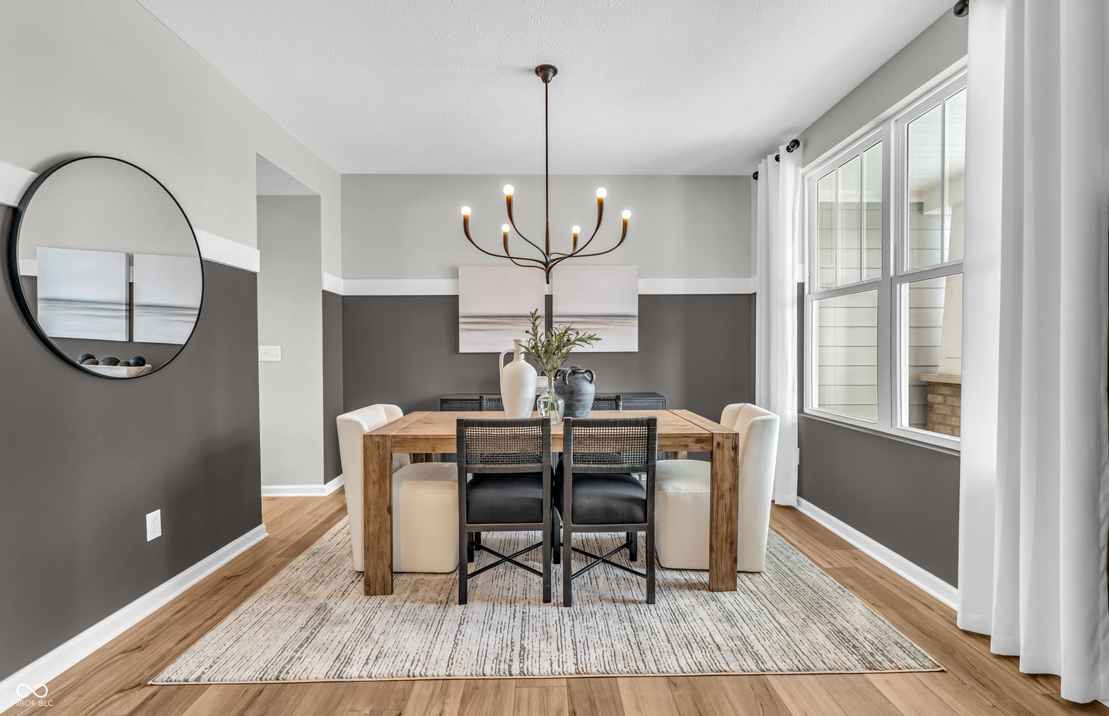 Modern dining with natural light and two-tone accent walls.