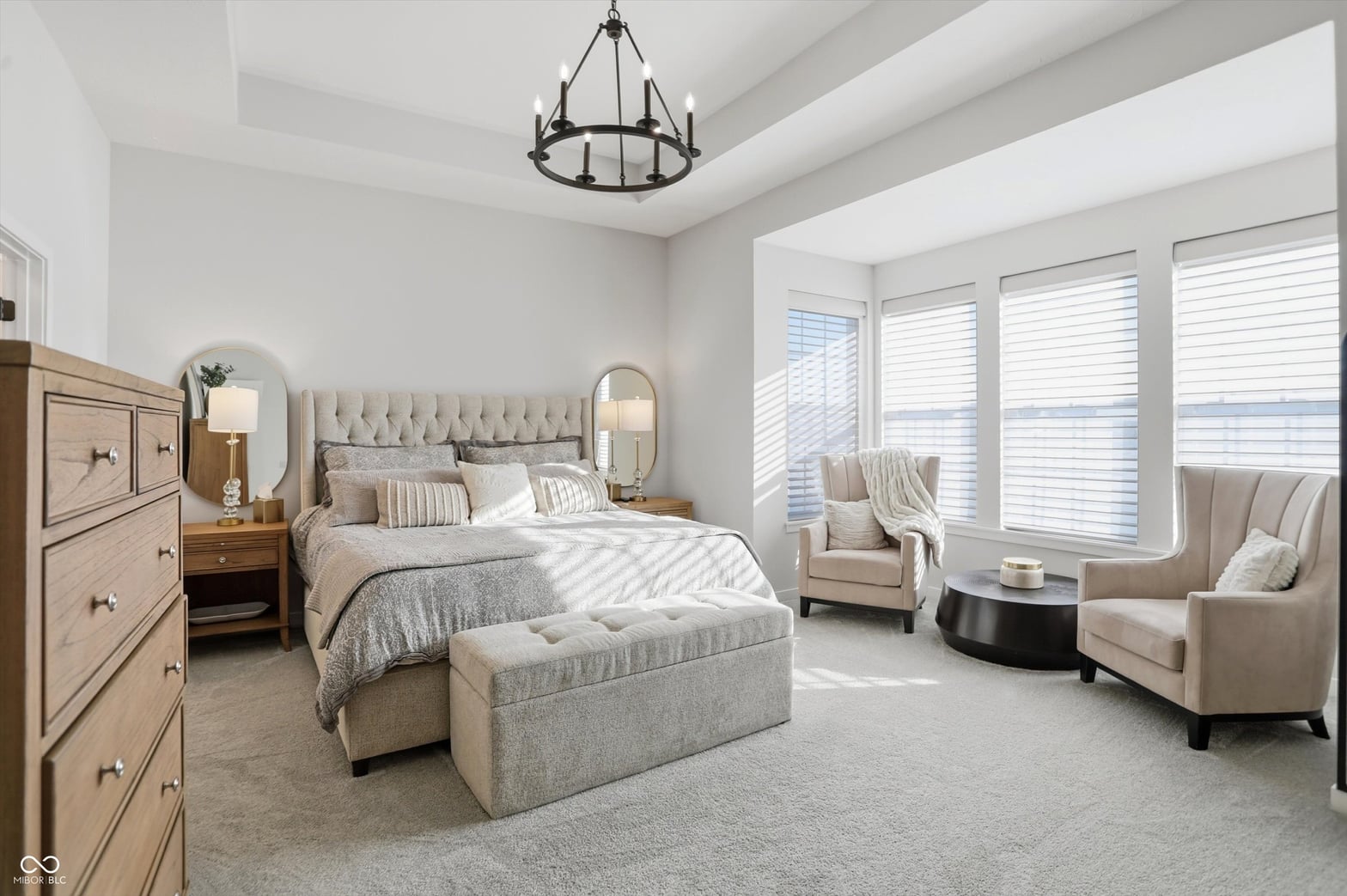 Luxurious primary suite with abundant natural light.