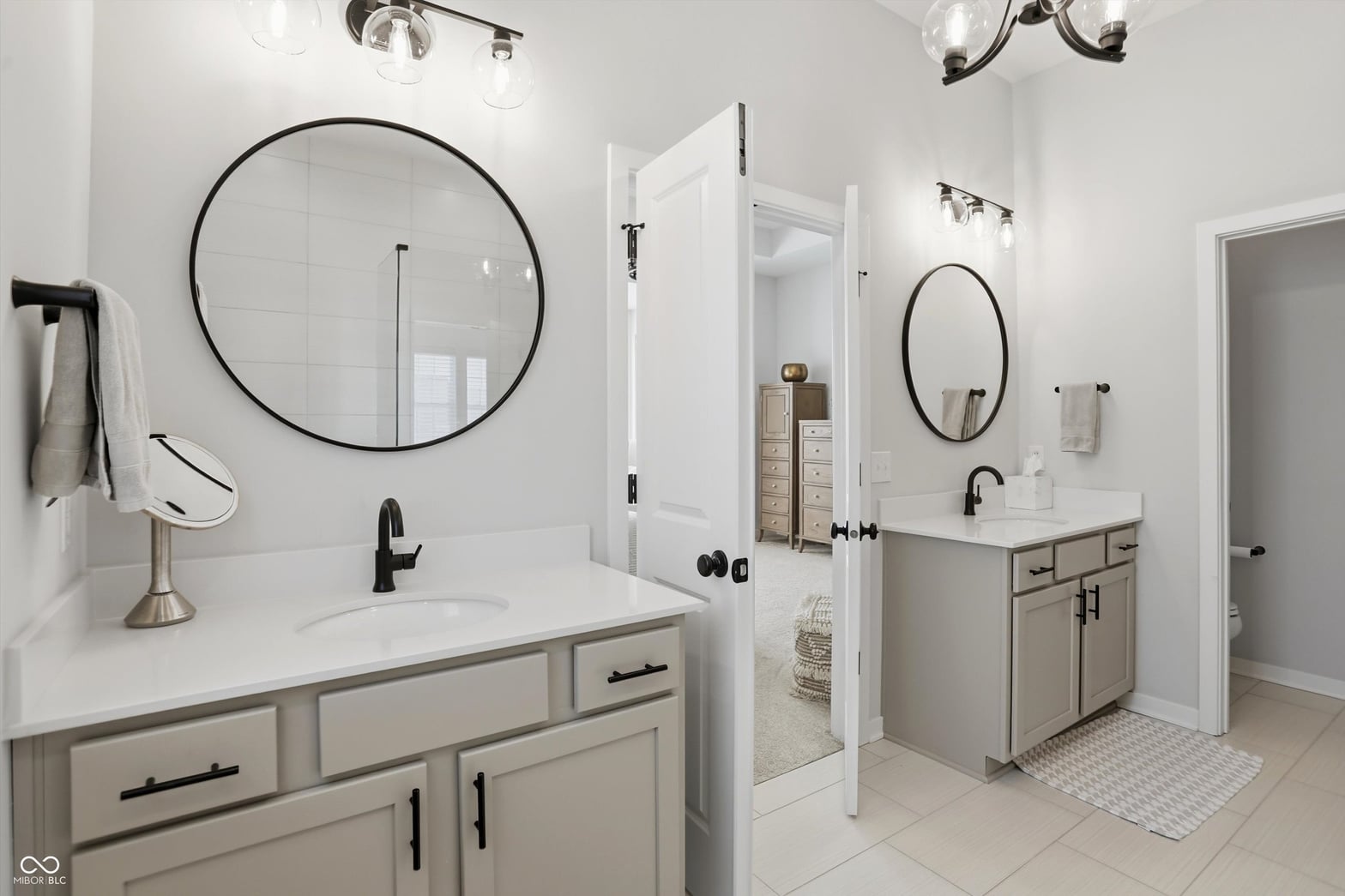 Luxurious primary bath with dual vanities and frameless shower.