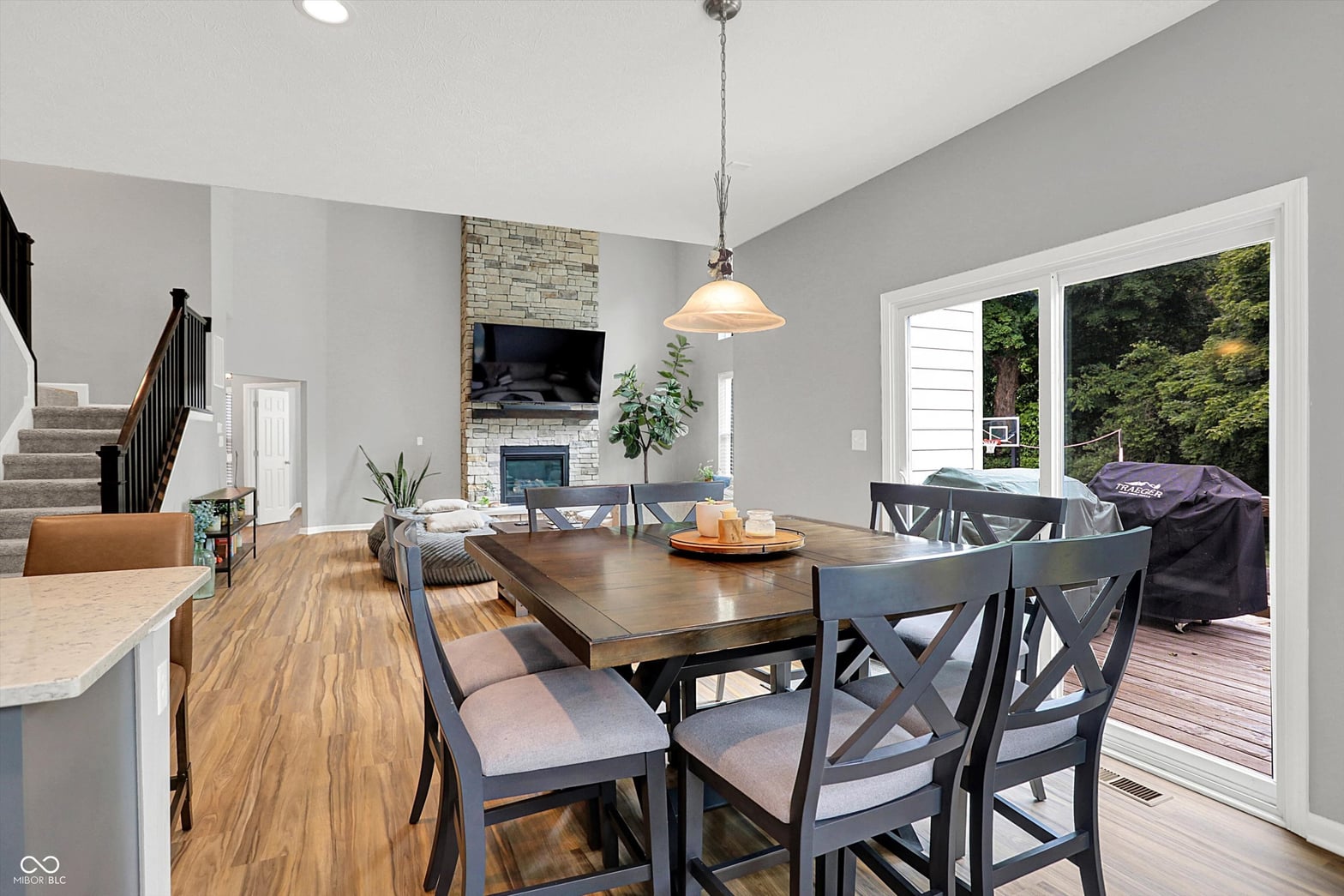 Bright open-concept dining with stone fireplace and deck access.