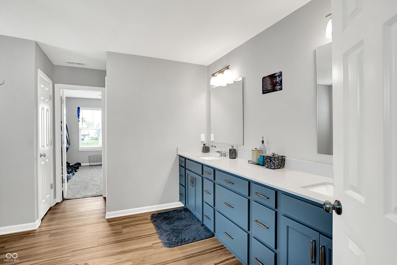 Spacious primary bath with stylish blue vanity and modern finishes.