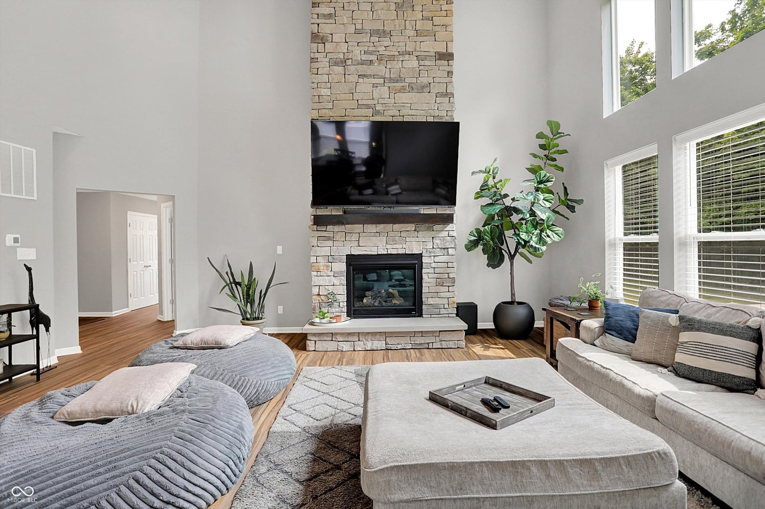Bright family room with floor-to-ceiling stone fireplace.
