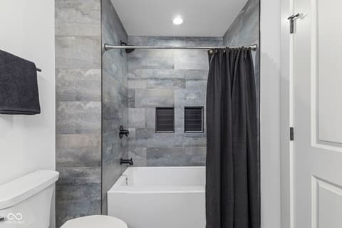 Primary bathroom at 5866 Harbour Town Drive, Noblesville, IN — Luxurious modern bathroom with tile shower and soaking tub.