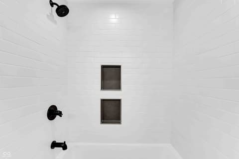 Primary bathroom at 5866 Harbour Town Drive, Noblesville, IN — Clean modern shower with sleek black fixtures and tile.