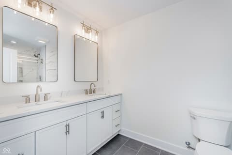 Primary bathroom at 5866 Harbour Town Drive, Noblesville, IN — Luxurious primary bath with dual vanity and marble surfaces.