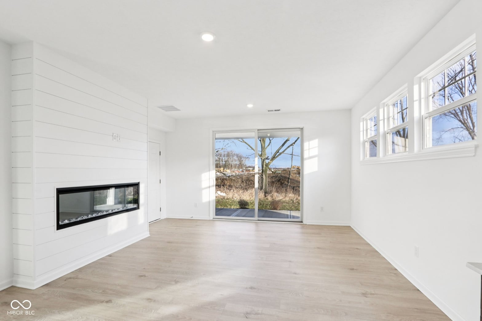 Modern living space with linear fireplace and natural light.