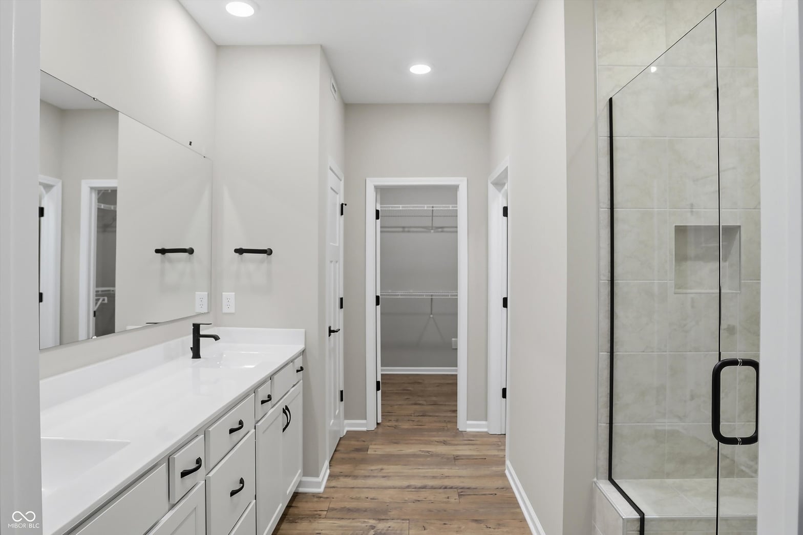 Luxurious primary bath with double vanity and frameless shower.