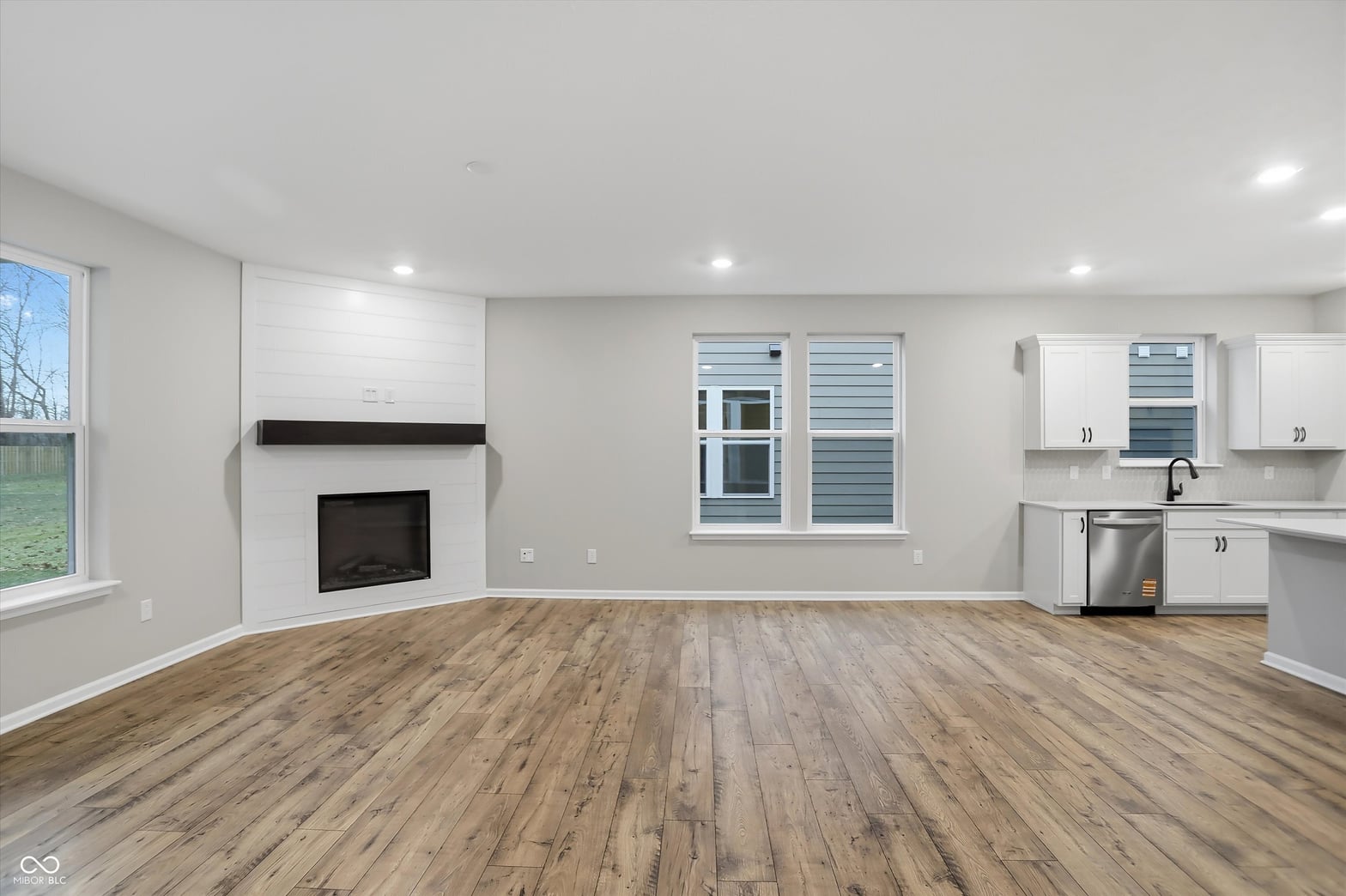 Bright open concept with fireplace and modern kitchen.