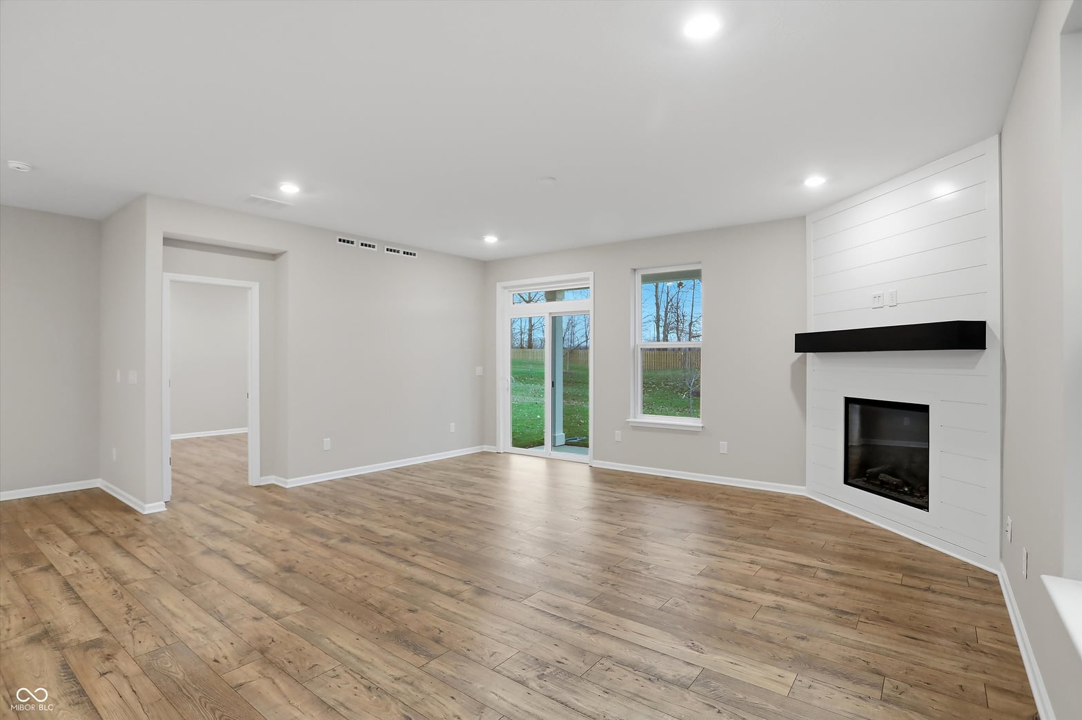 Bright, modern family room with fireplace and yard views.