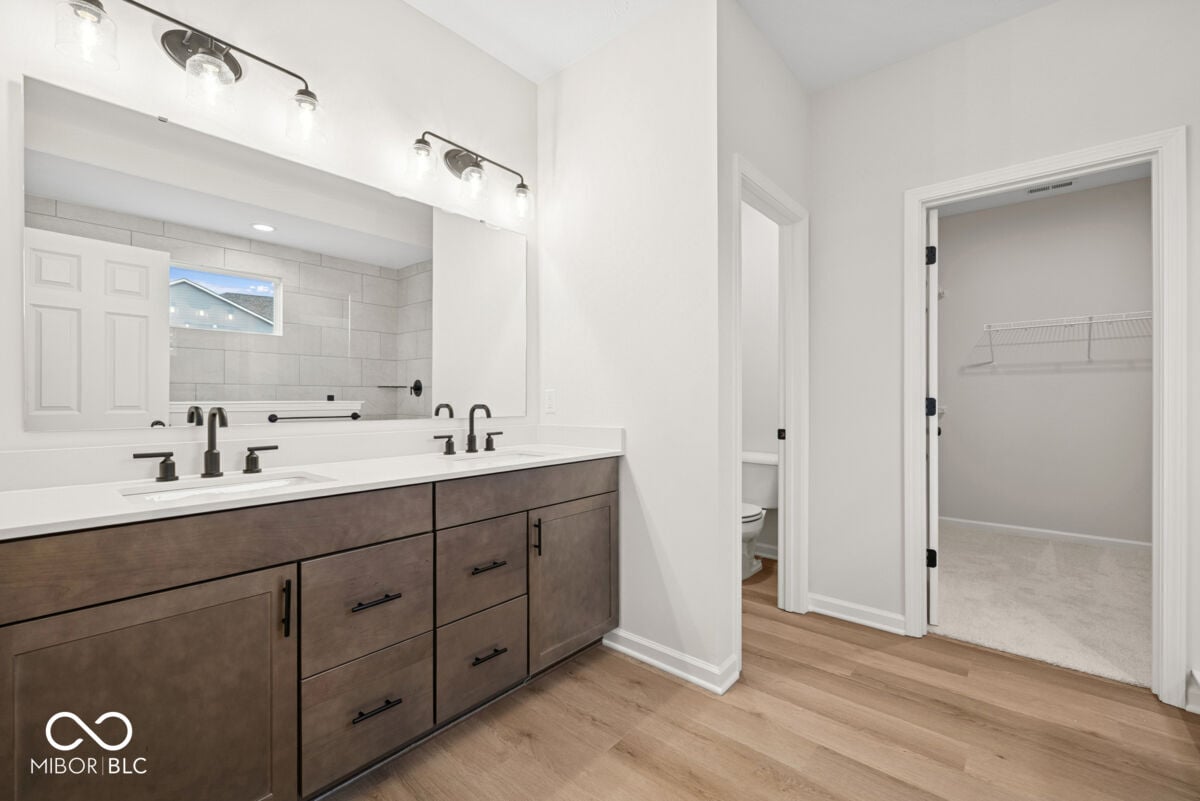 Spa-like primary bath with dual vanity and walk-in closet.