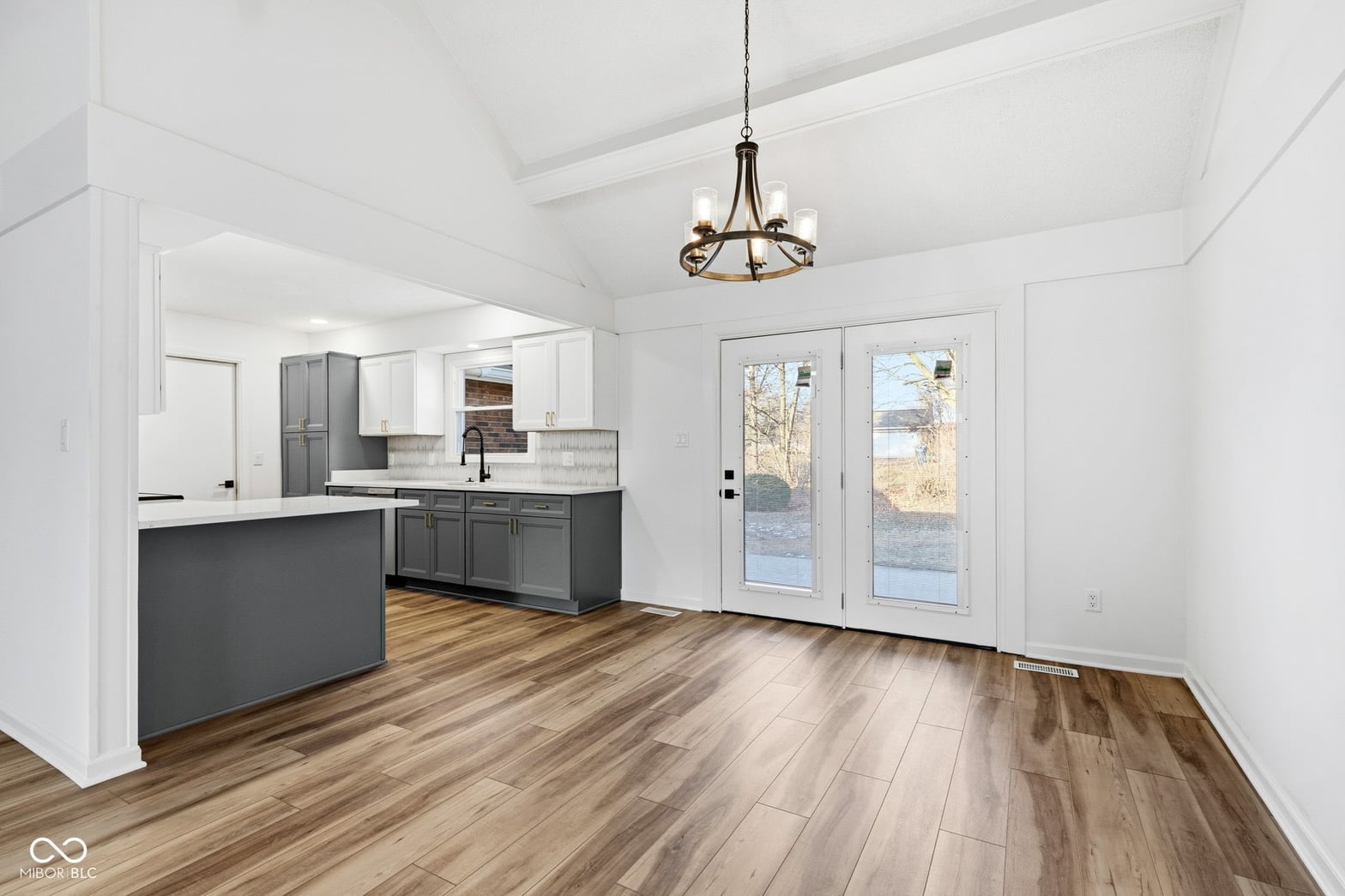 Bright modern kitchen with vaulted ceilings and outdoor access.