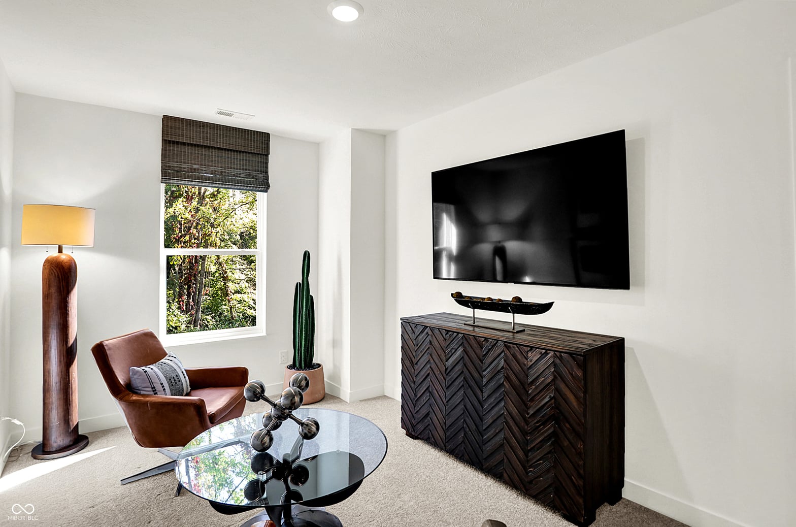 Modern family room with wall-mounted TV and designer finishes.