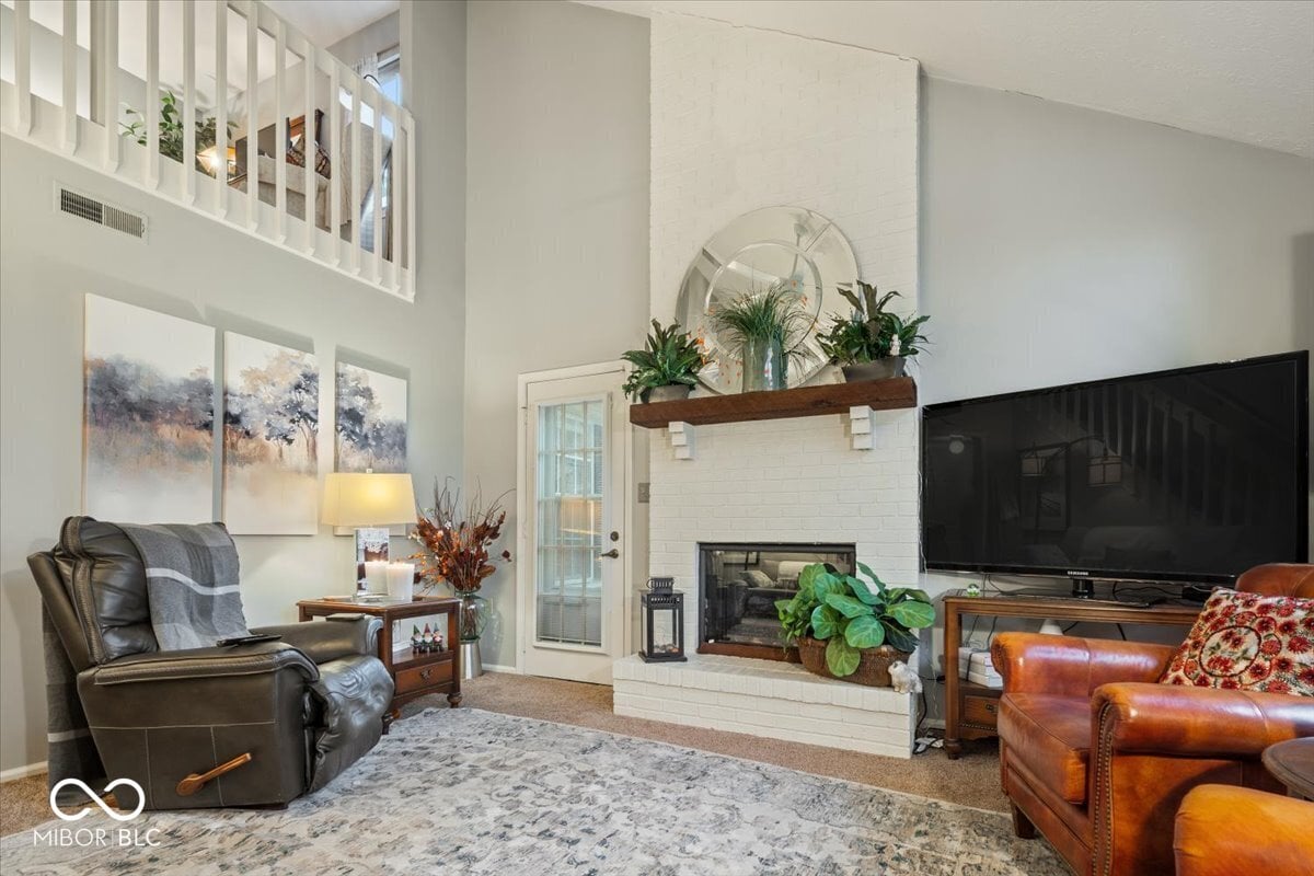 Living room at 7533 Castleton Farms North Drive, Indianapolis, IN — Bright living room with fireplace and soaring ceilings.