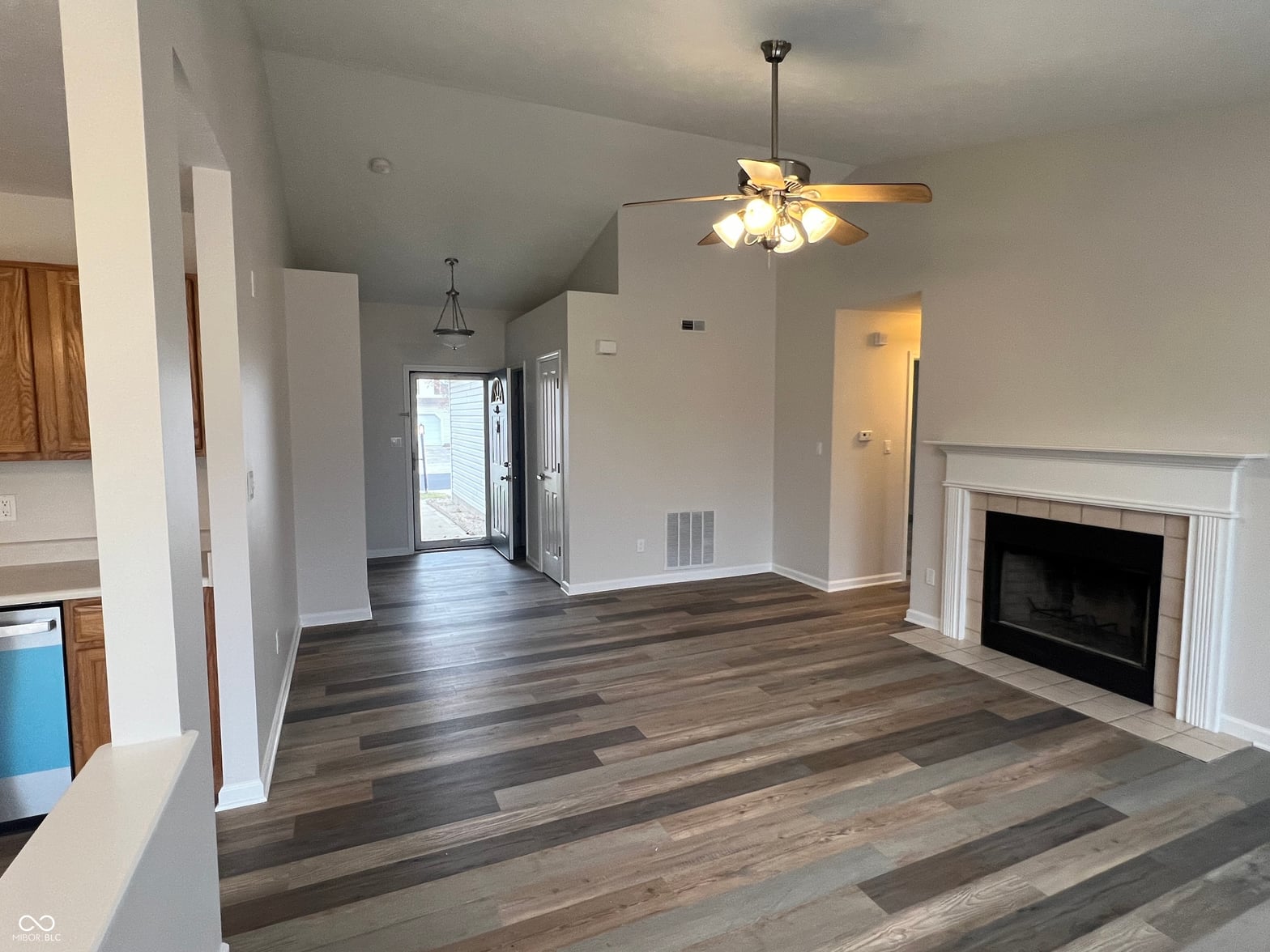 Spacious updated living room with fireplace and hardwood floors.