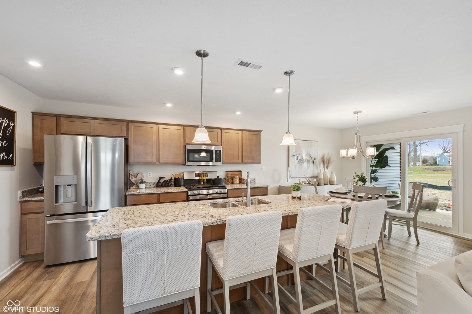 Bright open kitchen with granite island and outdoor access.