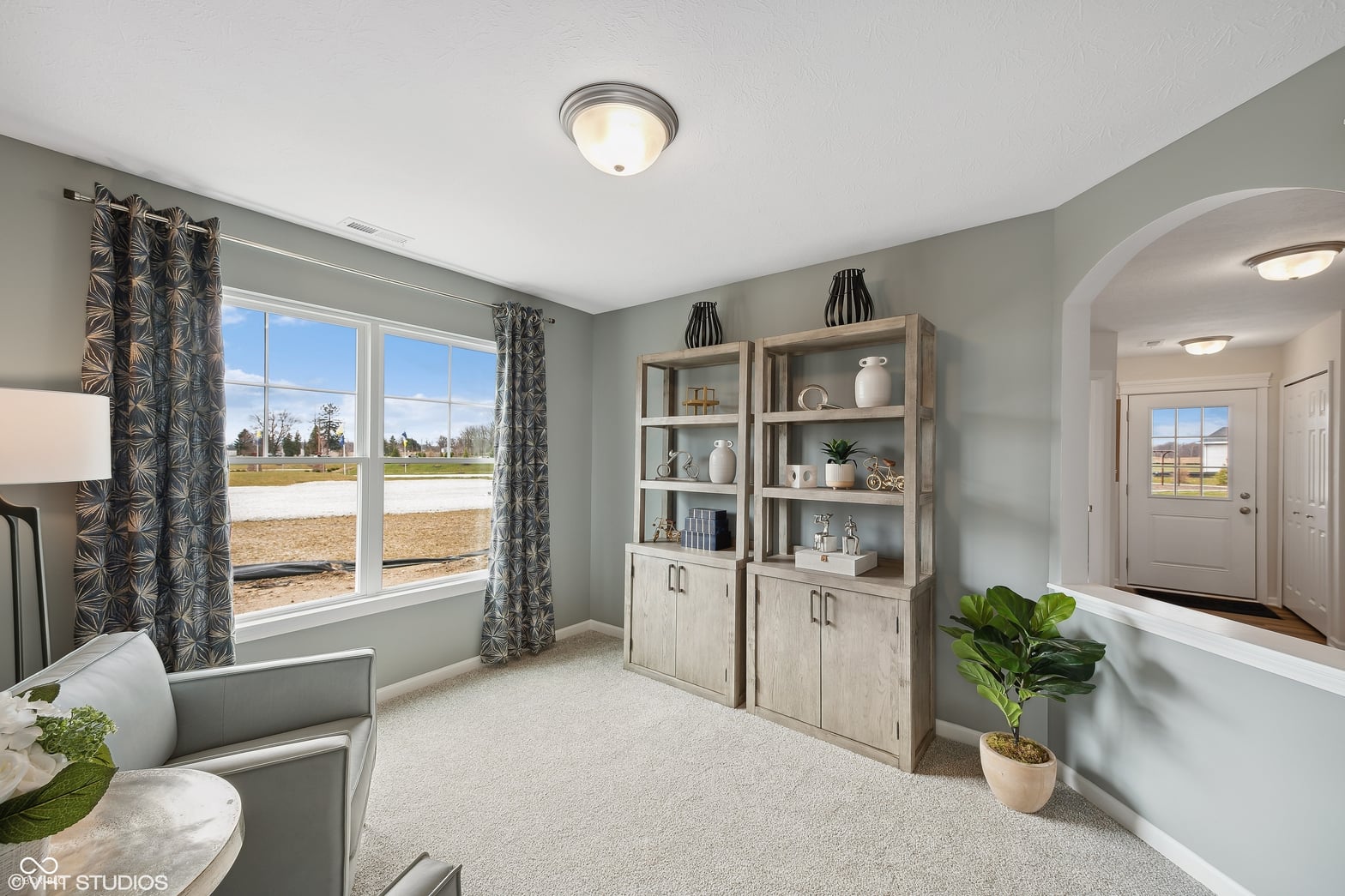 Bright family room with expansive windows and built-in storage.