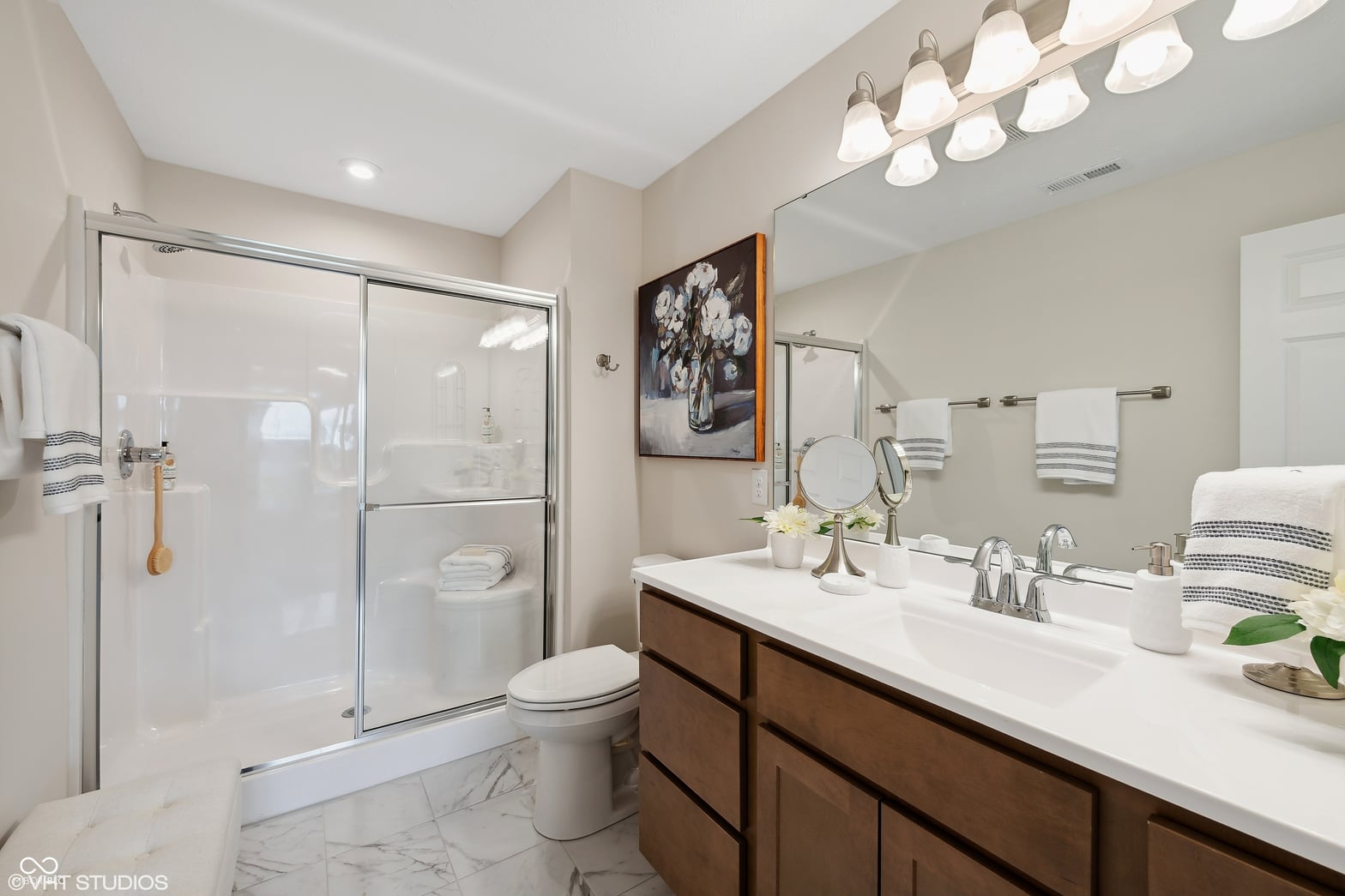 Luxurious primary bath with double vanity and frameless shower.